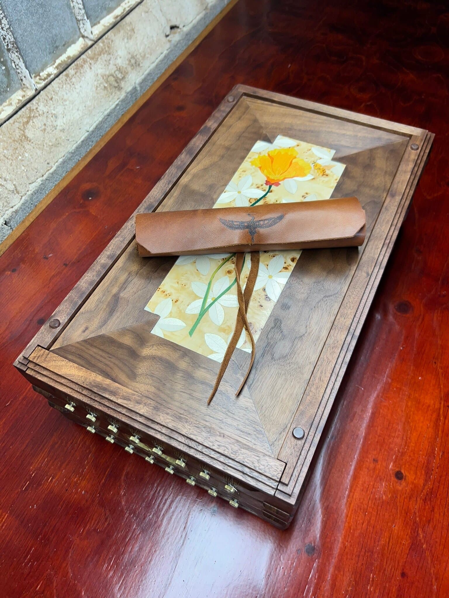 A leather roll tied across the chitarra's poppy marquetry panel