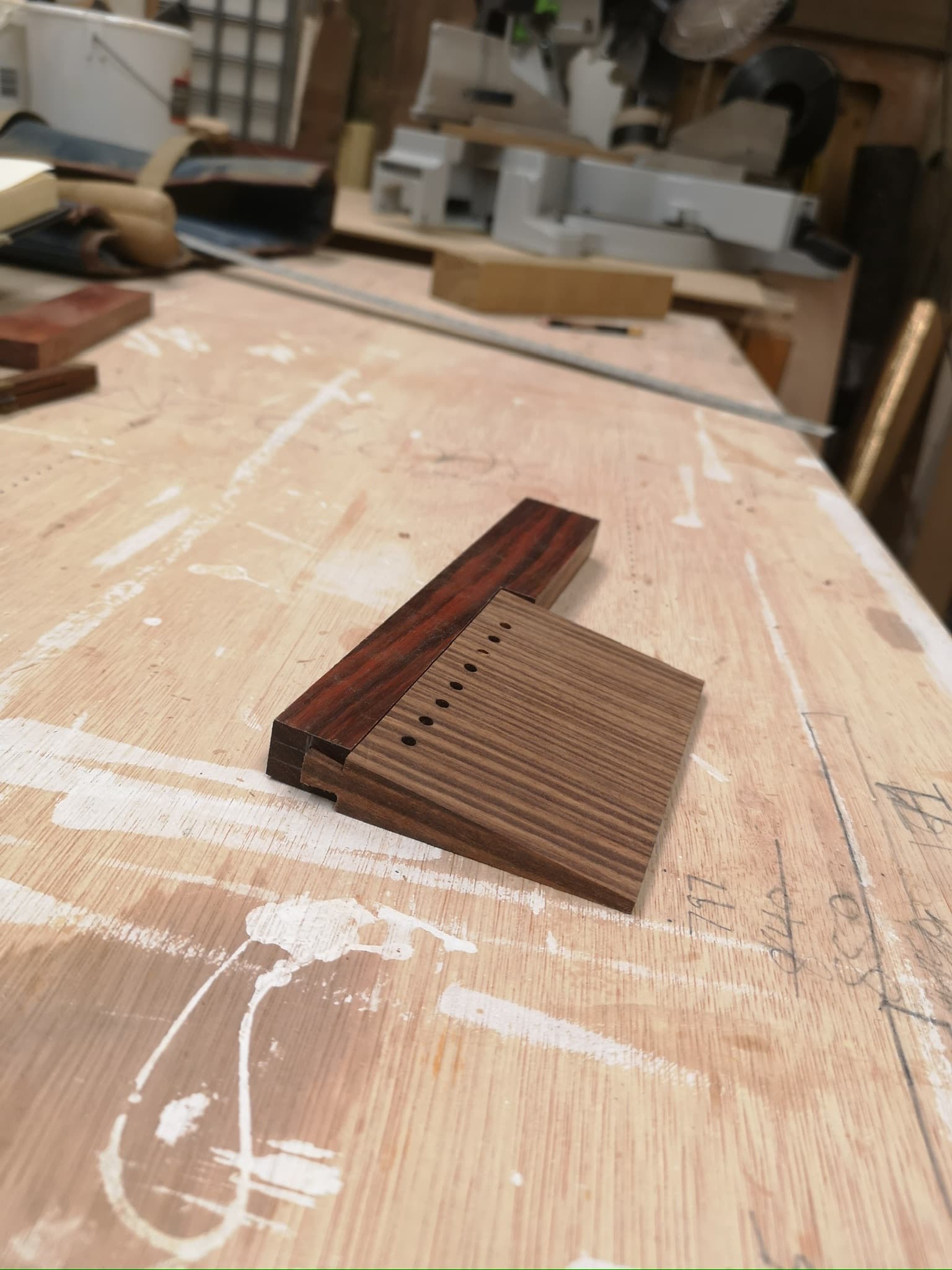 The comb blank on the bench, drilled where its teeth will part