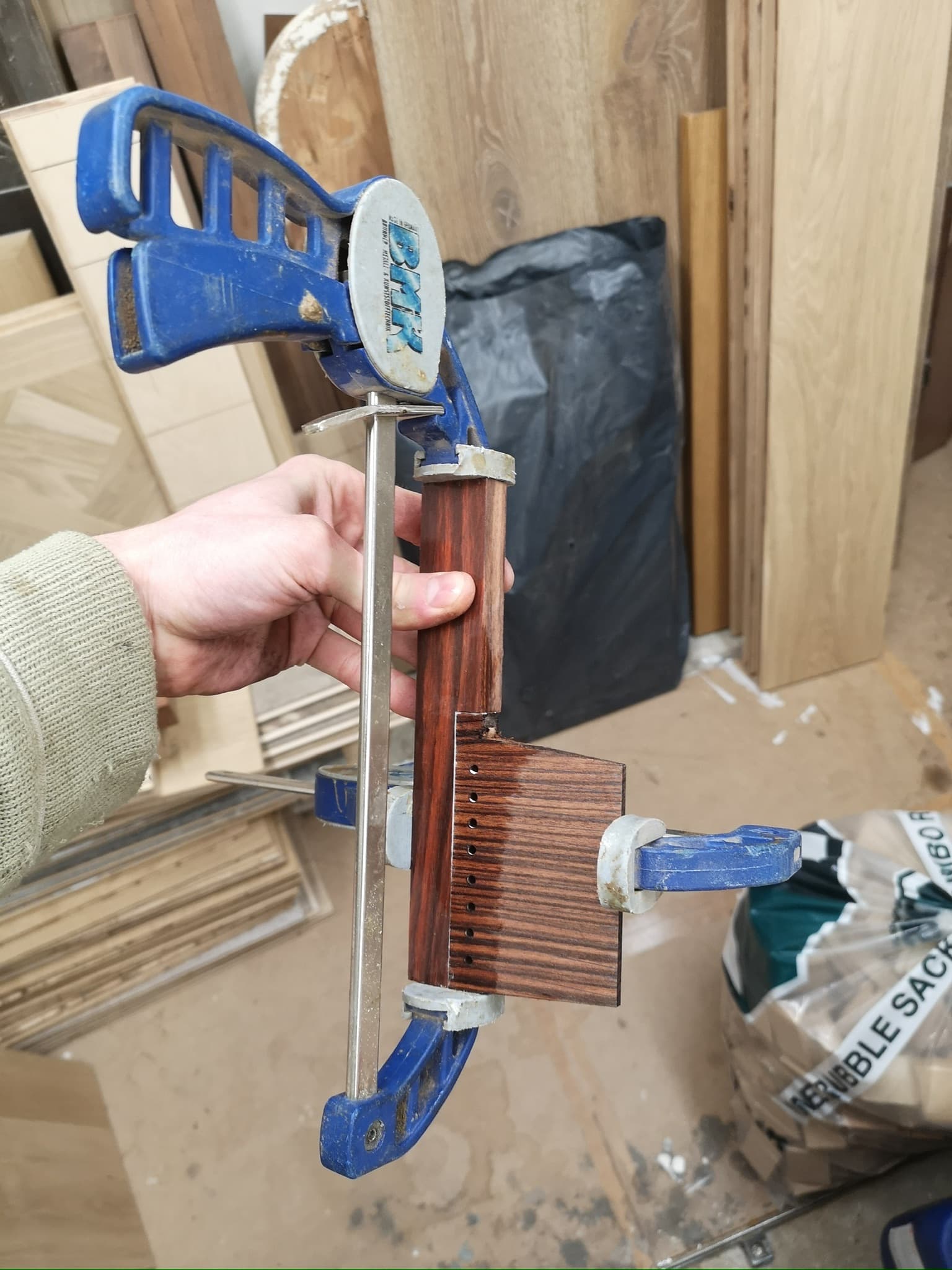The comb's spine glued to its blank in a sash clamp