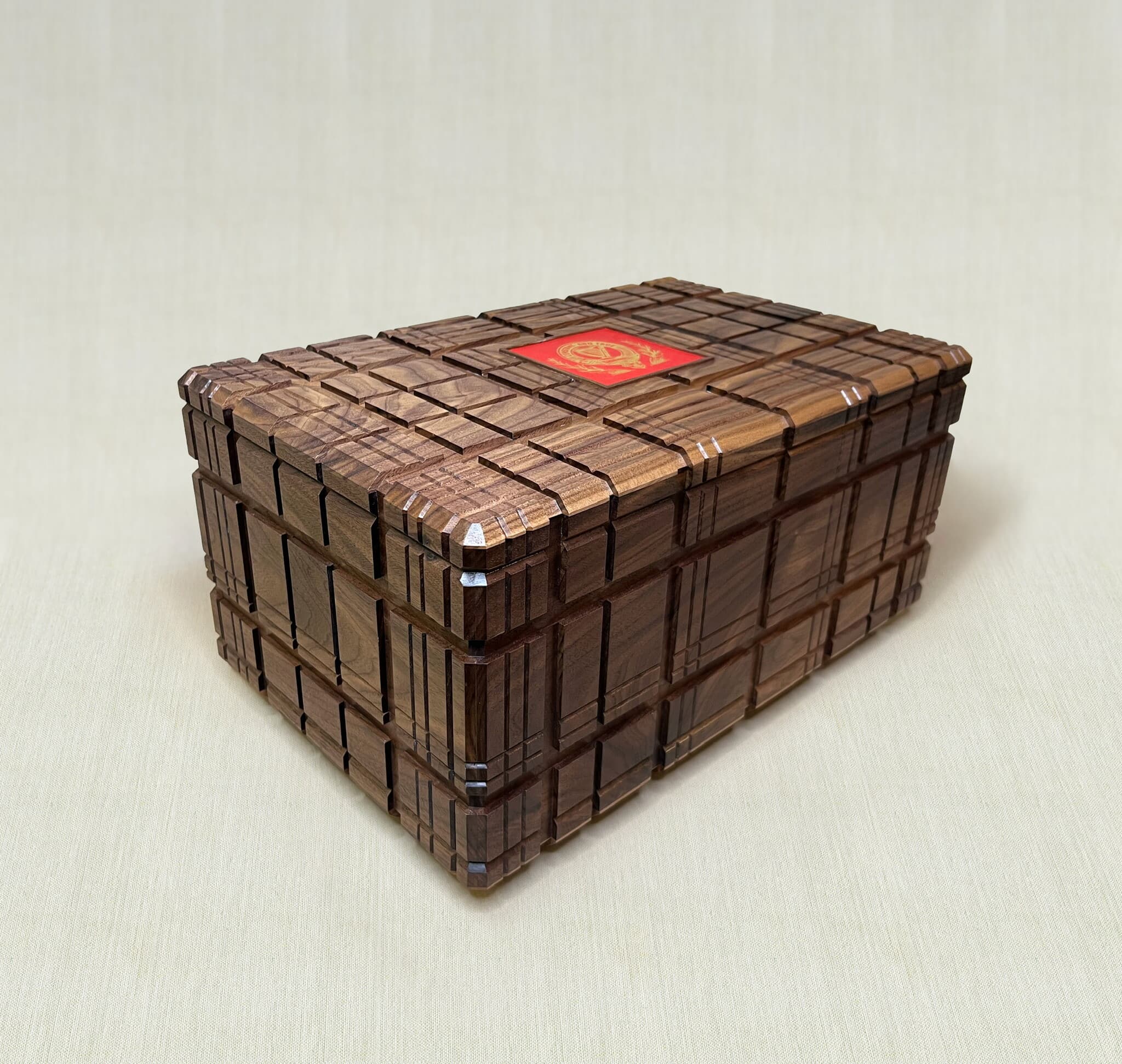 The puzzle box closed, tartan grooves carved across the walnut