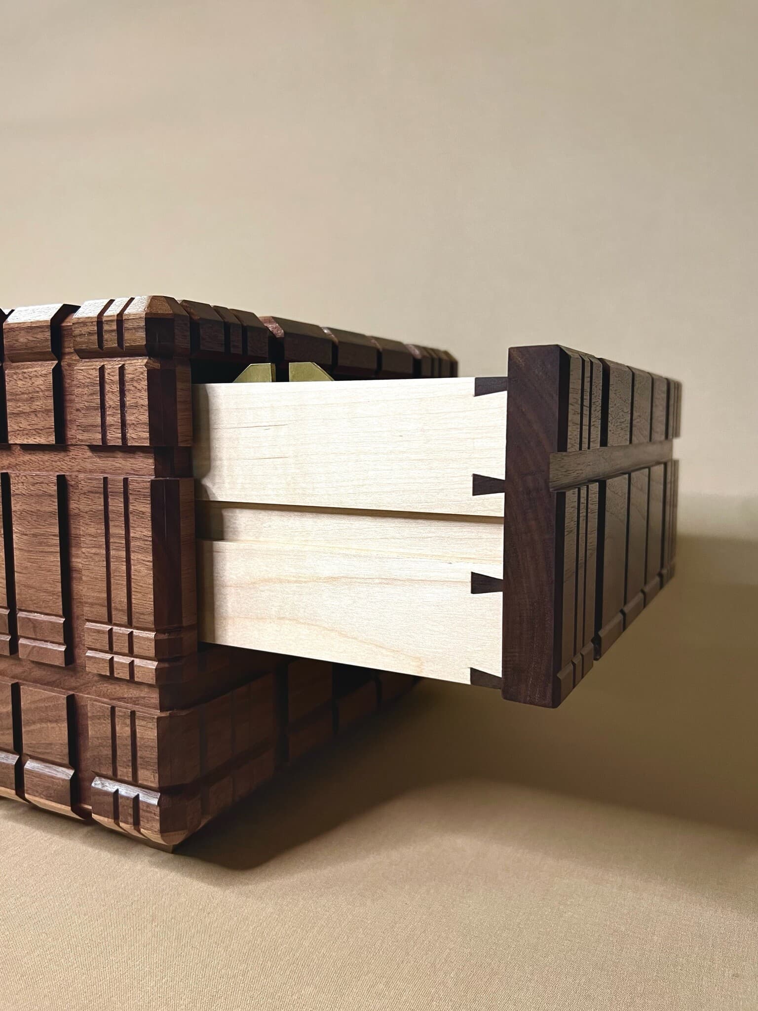 A hand-cut dovetailed maple drawer sliding out of the box