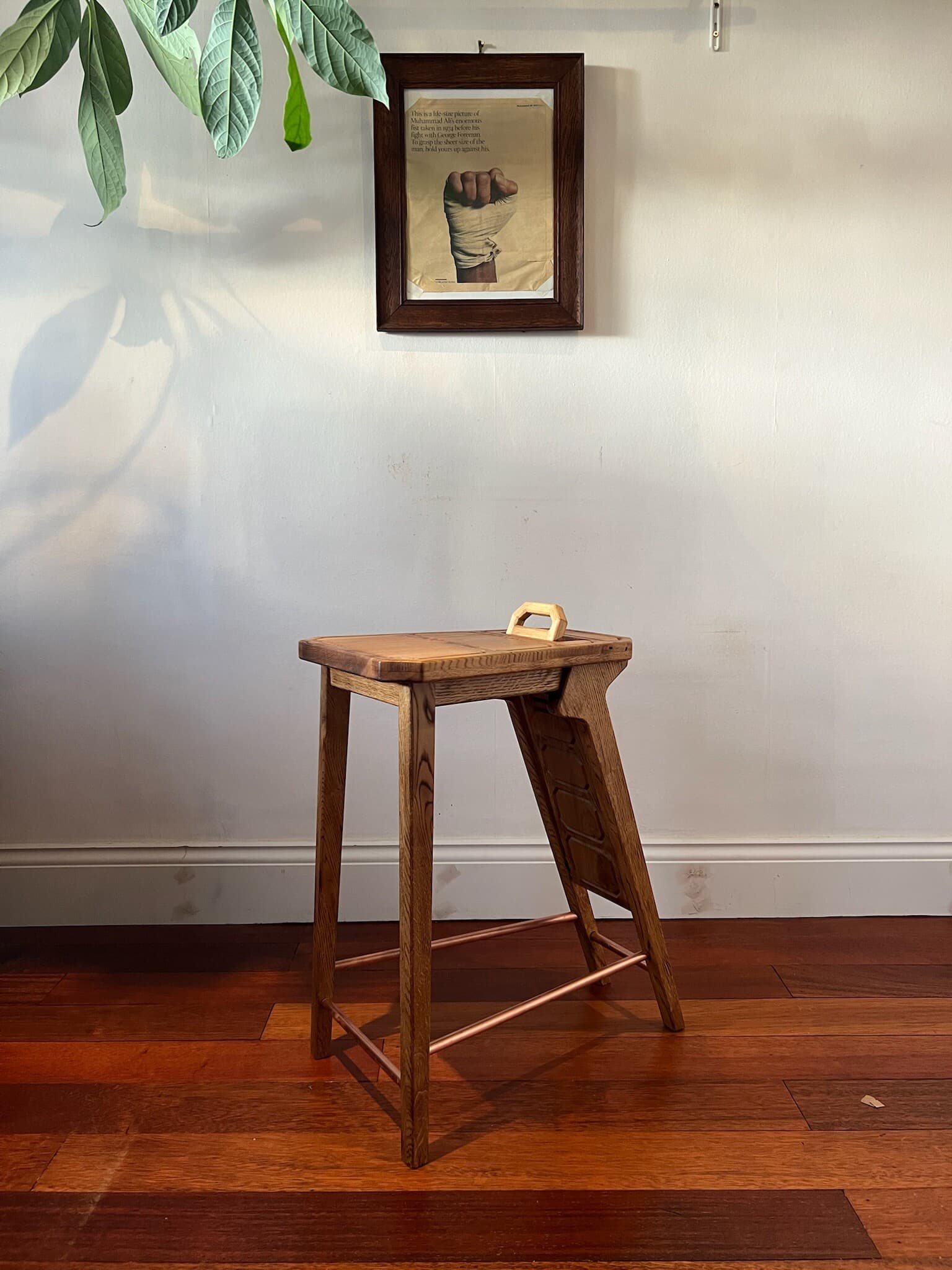 The stool side on, only the backrest's handle showing above the seat