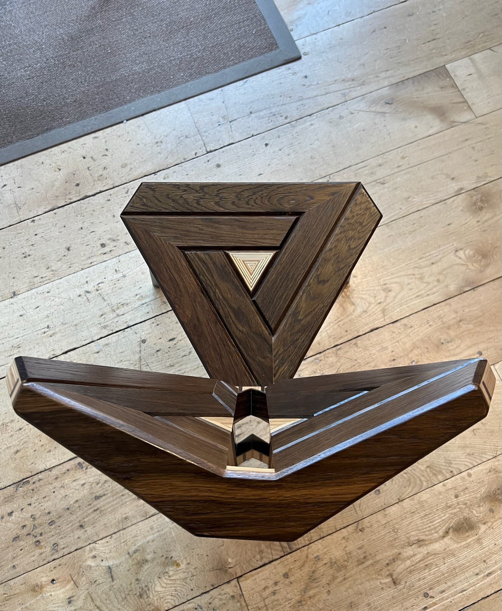 Seat and back from above, triangles of dark oak nested around a pale centre