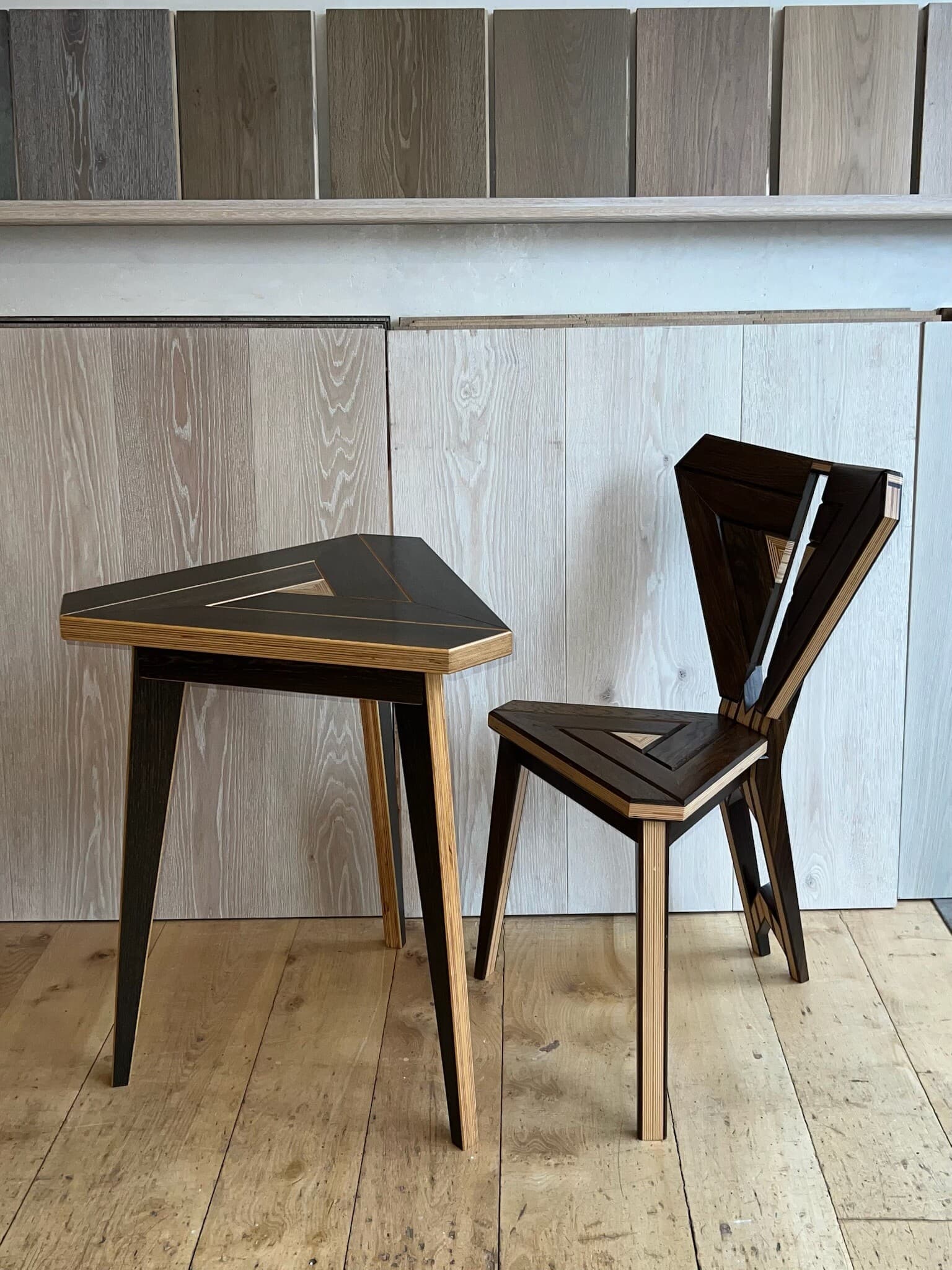 The chair beside a three-legged table with the same triangular top
