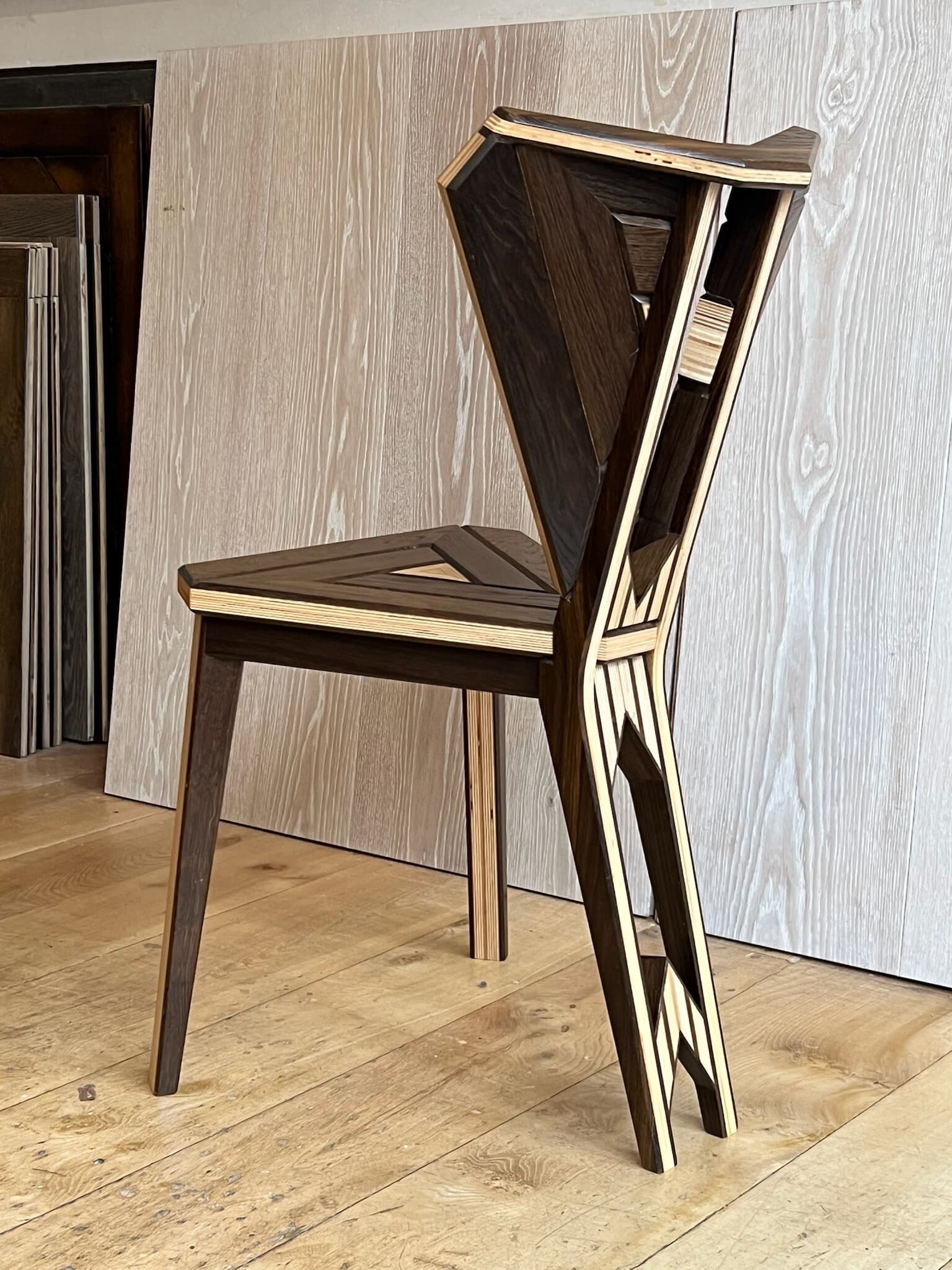 The chair in profile, its back leaning away from a single rear leg