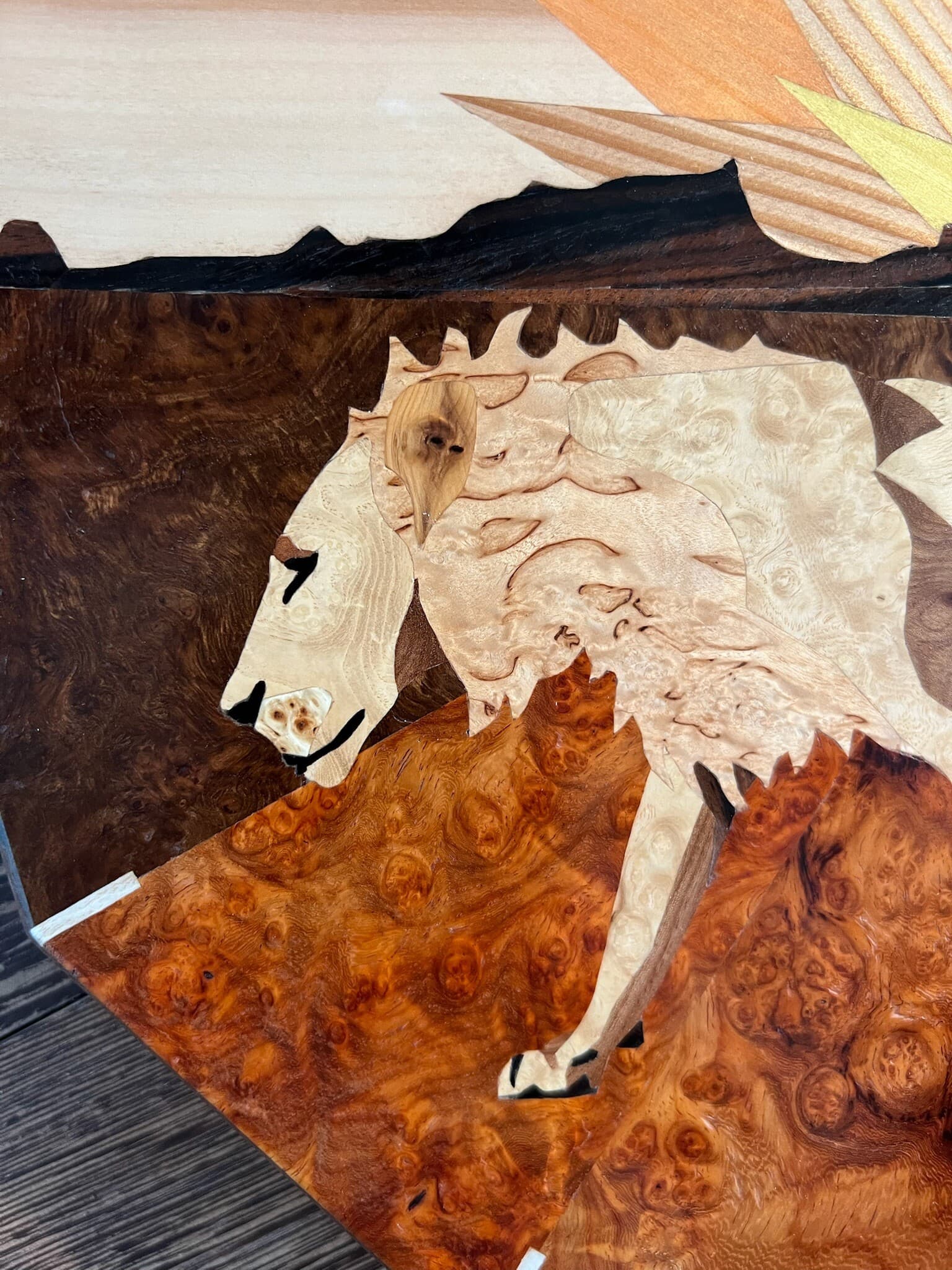 Detail of the lion, cut from pale burr veneer