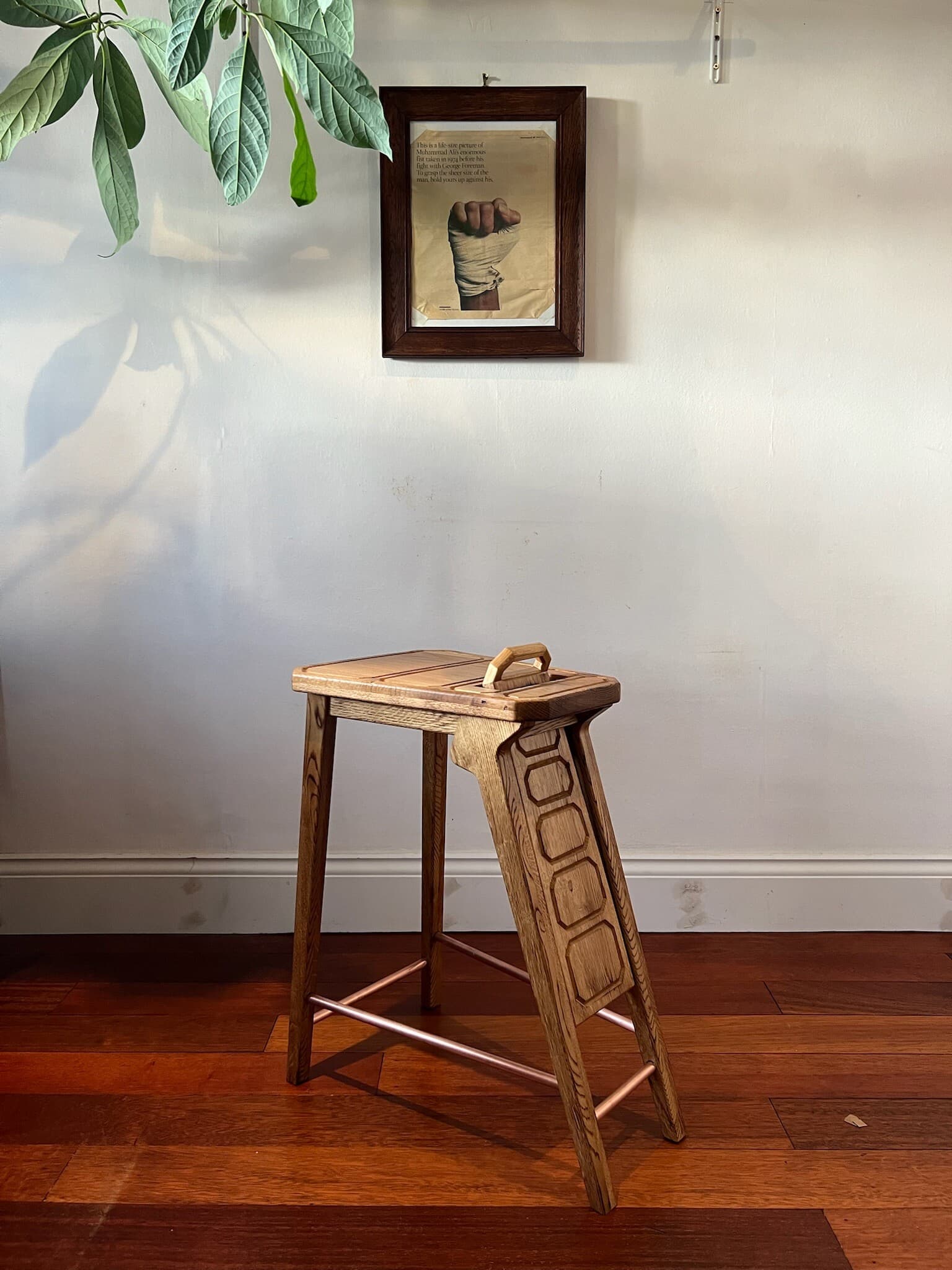 The lowered backrest hanging behind the seat, its carved panels facing out