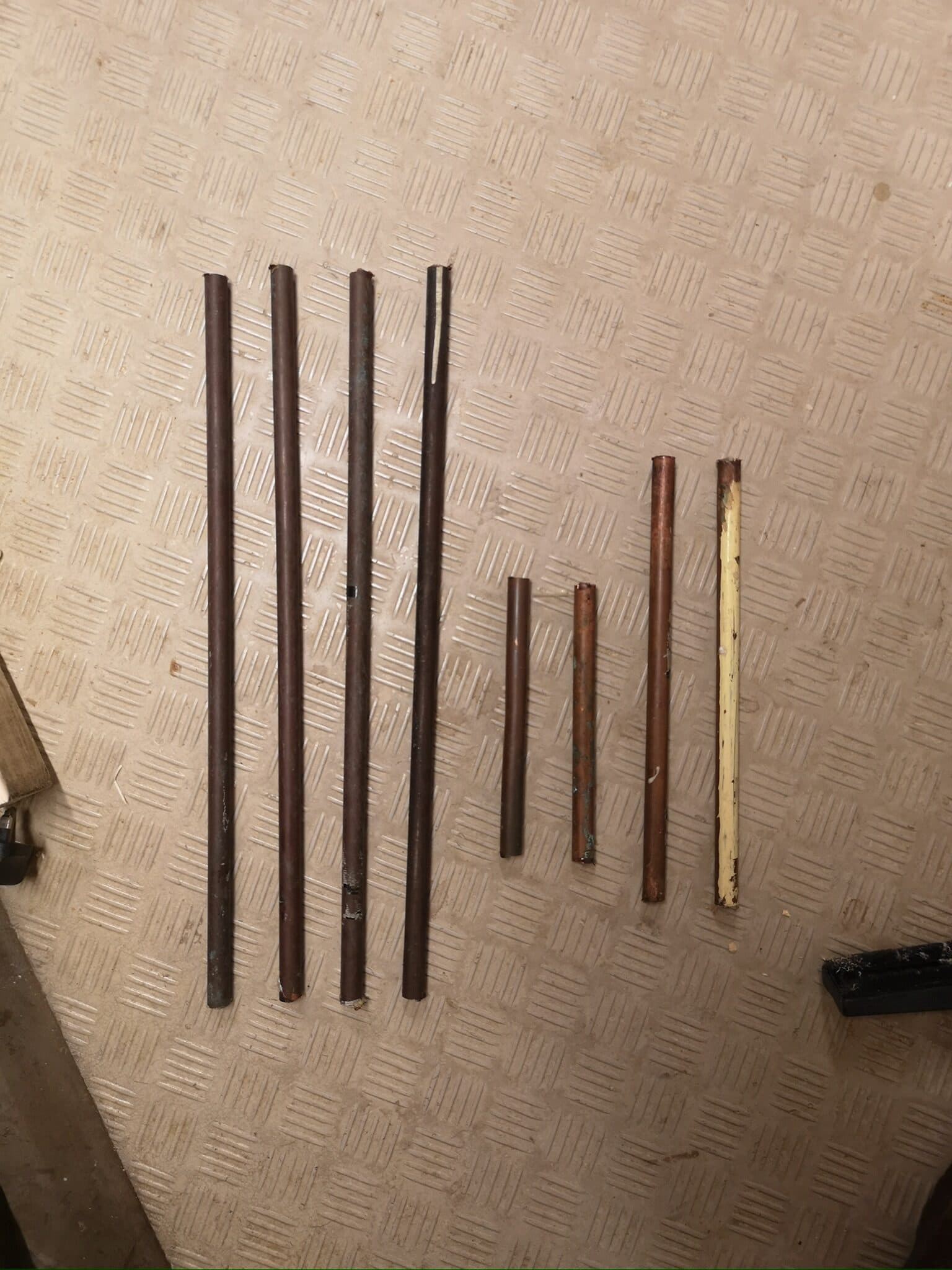 The copper pipe cut into stretchers, still tarnished
